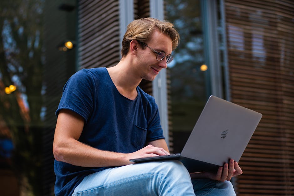 Young man working on laptop outdoors